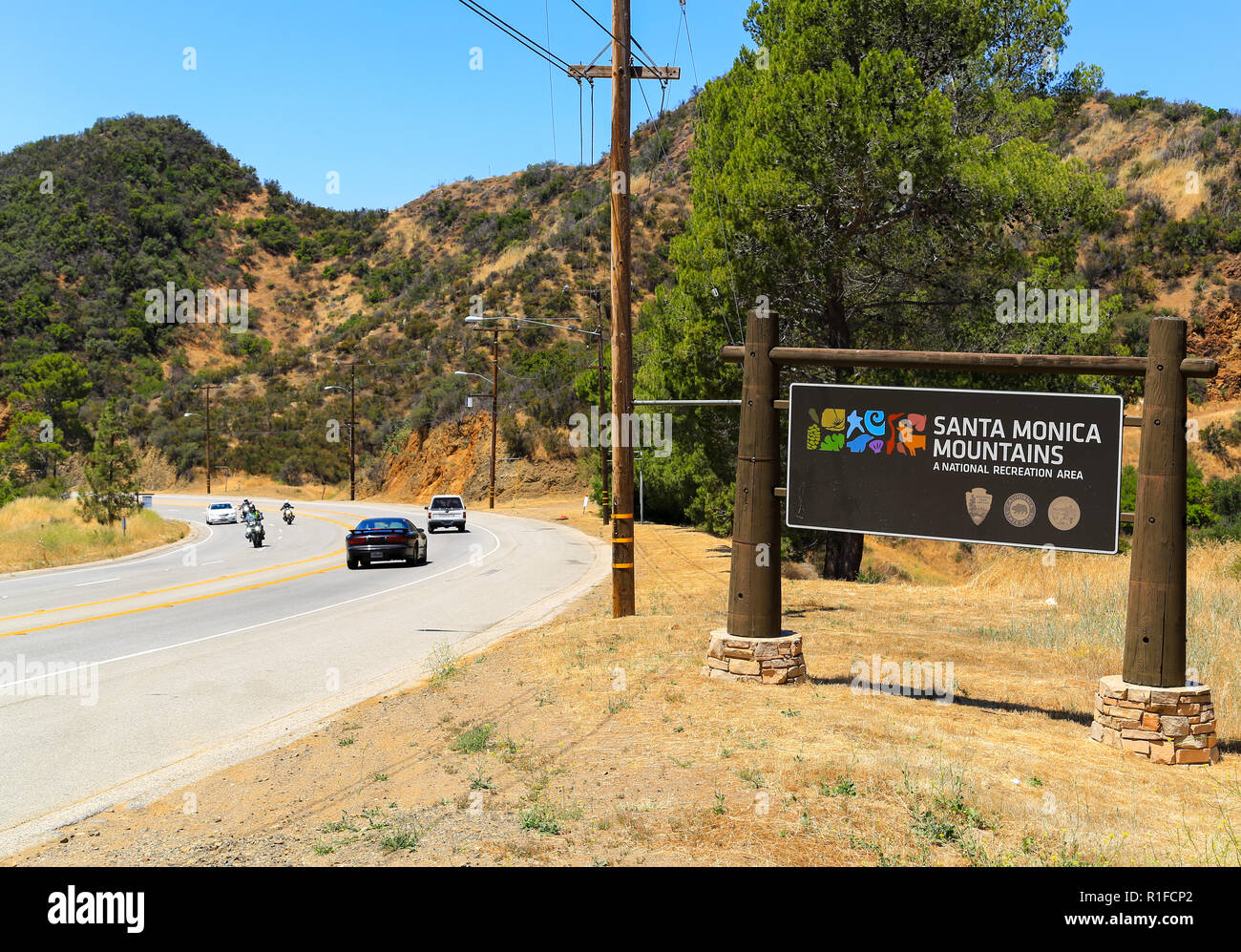 Agoura Hills, in California, Stati Uniti d'America - 28 Maggio 2017: segno che mostra l'ingresso della Santa Monica montagne, una National Recreation Area. Ciclisti e automobili sono Foto Stock