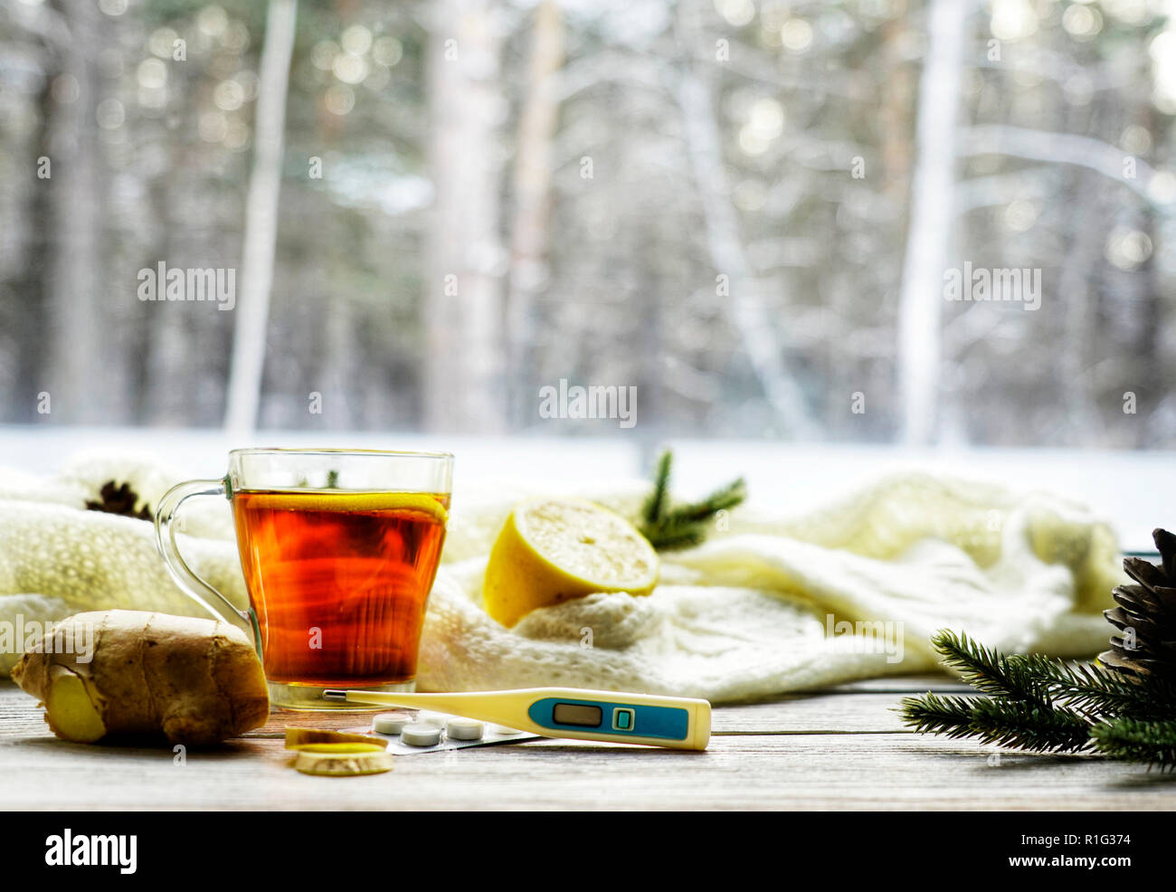 Vista superiore parola di legno malato, tè con limone, termometro, zenzero, miele, compresse e foglie secche su uno sfondo bianco. flat laico, spazio per il testo Foto Stock