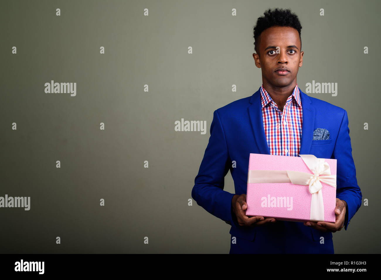Bel giovane imprenditore africano azienda confezione regalo contro colo Foto Stock