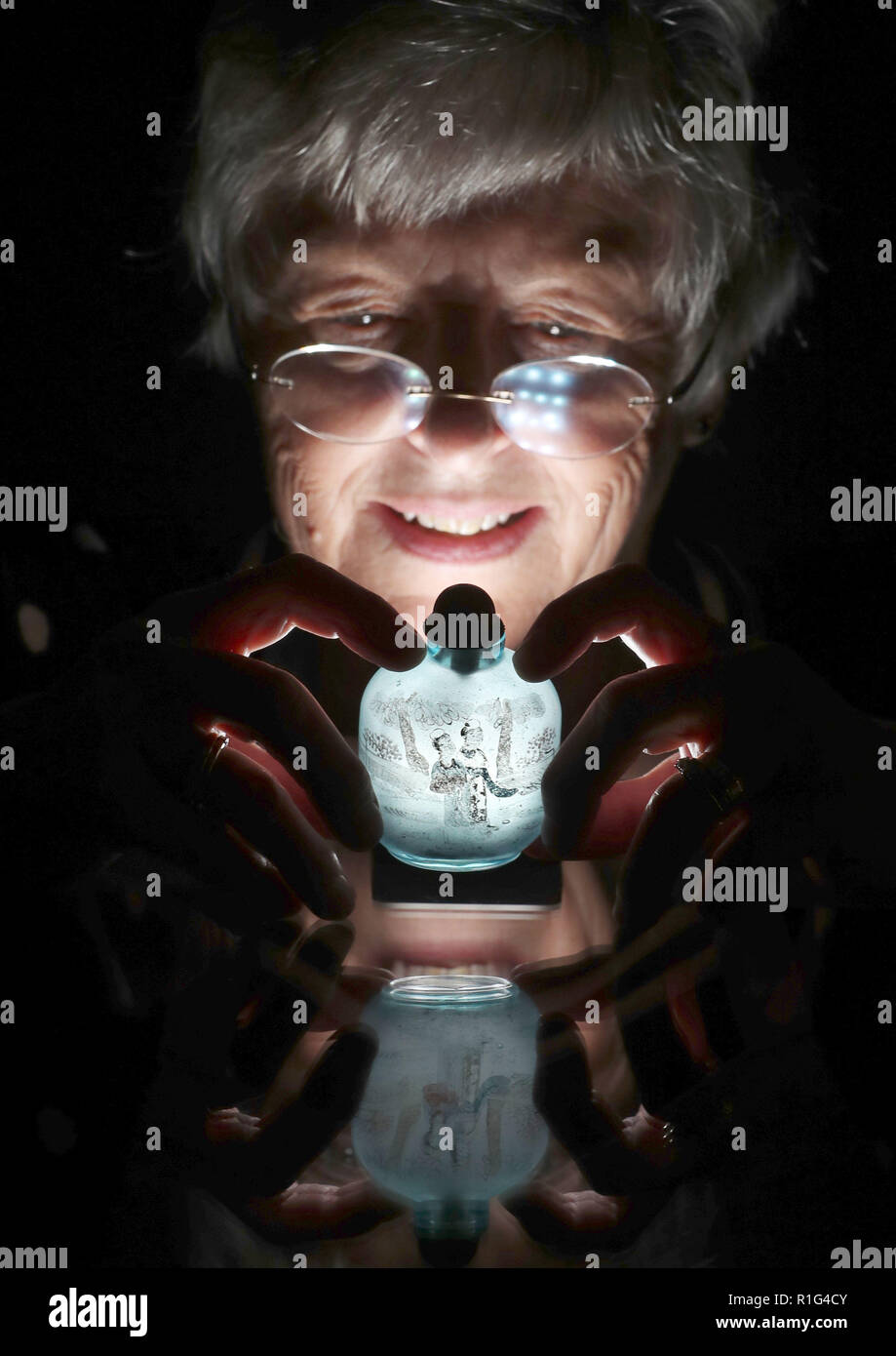 Casa d'Aste assistant Lorna MacGregor ispeziona un XIX secolo il tabacco da fiuto di vetro bottiglia che viene visualizzato in Bonhams, Edimburgo prima di esso è offerto in asta come parte di un'arte asiatica vendita il prossimo giovedì. Foto Stock