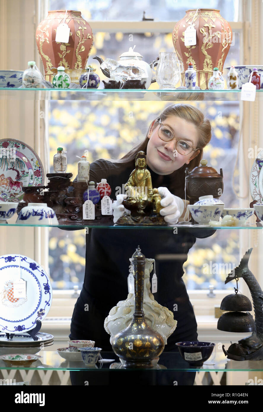 Casa d'Aste assistant Jaine Heggie prende uno sguardo più da vicino a una dinastia Ming gilt-gruppo bronzeo di Guanyin e Sudhana e altri elementi che è visualizzato a Bonhams, Edimburgo prima di esso è offerto in asta come parte di un'arte asiatica vendita il prossimo giovedì. Foto Stock