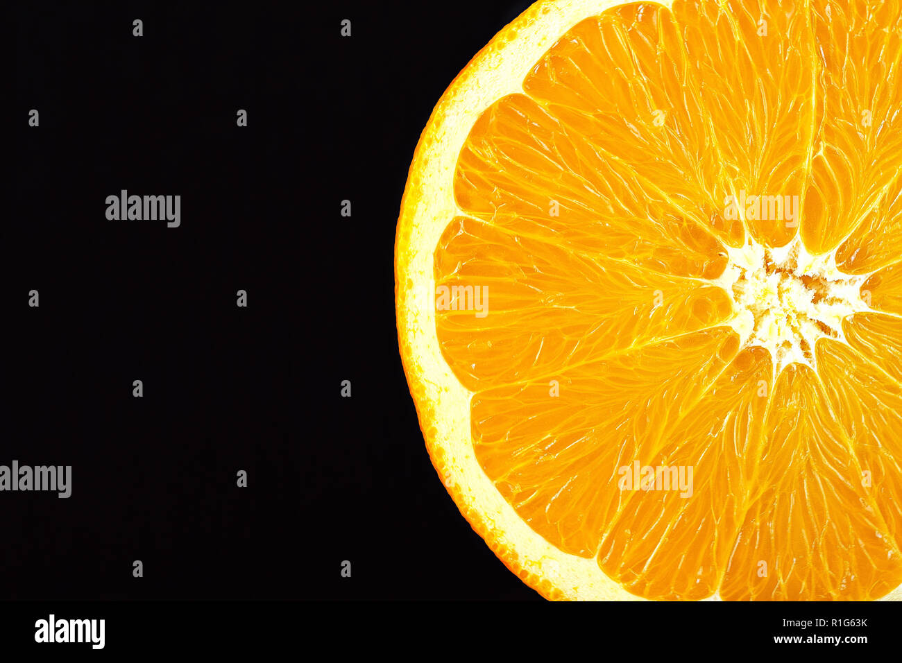 Affettato closeup arancione su sfondo nero. chiaramente visibile la consistenza della polpa di colore arancione. spazio per il testo Foto Stock