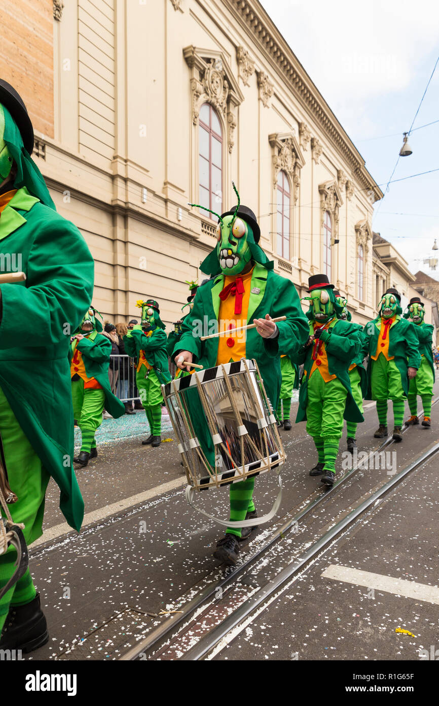 Il Carnevale di Basilea. Steinenberg, Basilea, Svizzera - Febbraio 21st, 2018. Il gruppo Carnival in Cavalletta verde costumi giocando rullante Foto Stock