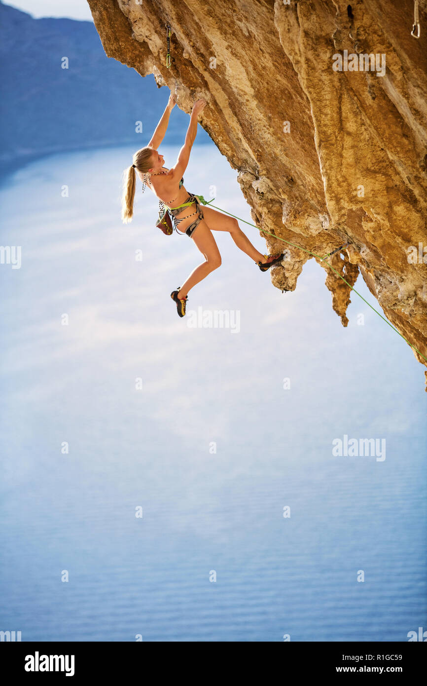 Giovani femmine rocciatore sull impegnativo percorso sulla scogliera. Kalymnos Island, Grecia. Foto Stock