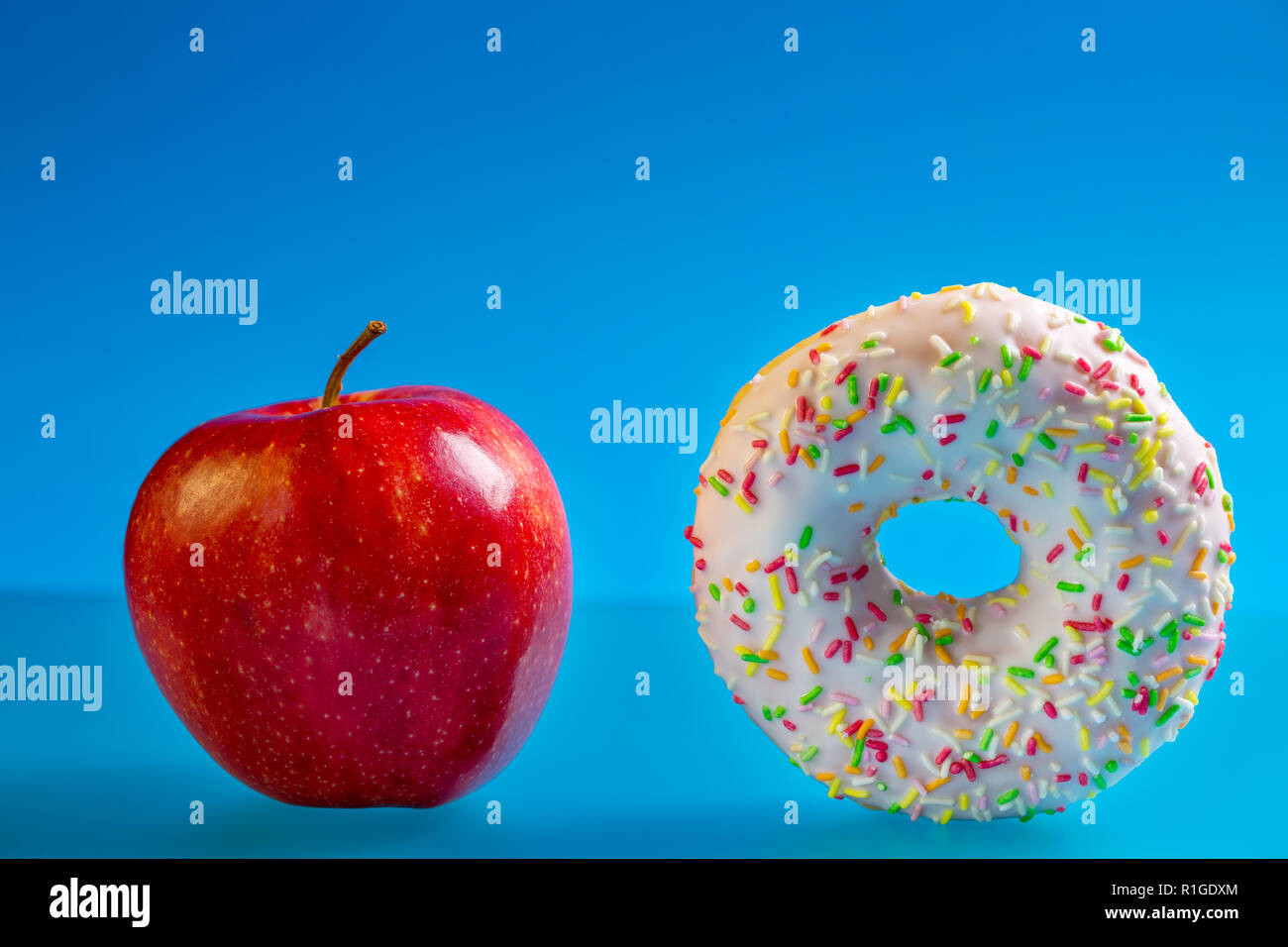 Apple e ciambella, concetto di scelta la salute e la dieta malsana. Foto Stock