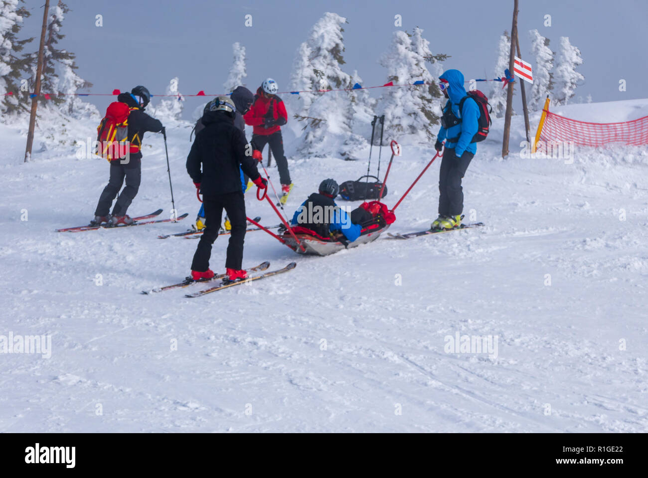 Ski team di soccorso con slitta barella, porta aiuto a sciare durante cattive condizioni meteorologiche. Foto Stock