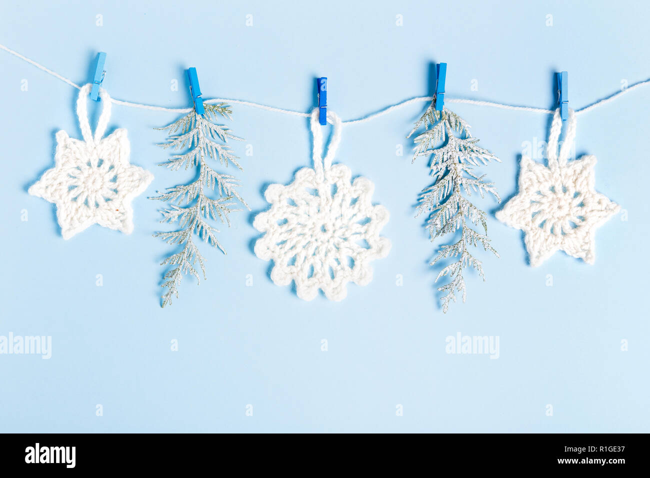 Composizione di natale di maglia fiocchi di neve bianca e stelle su sfondo blu. Vista superiore, piana, laici copia spazio. Foto Stock