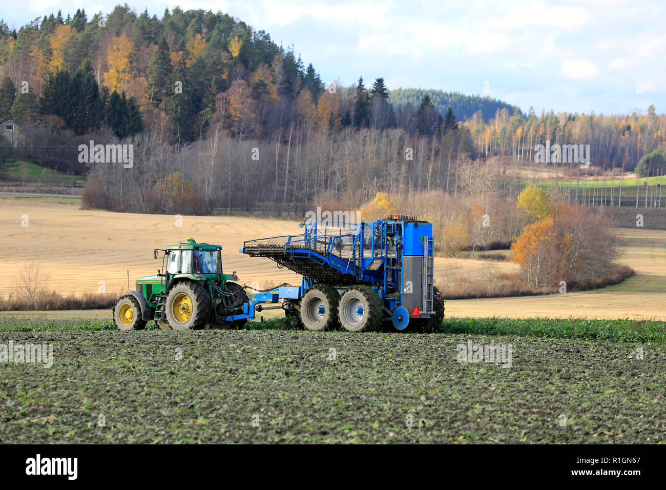 Salo, Finlandia - 21 Ottobre 2018: il contadino di raccolti di barbabietole da zucchero con John Deere trattore 7700 e Edenhall 743 semovente in autunno nel sud della Finlandia. Foto Stock