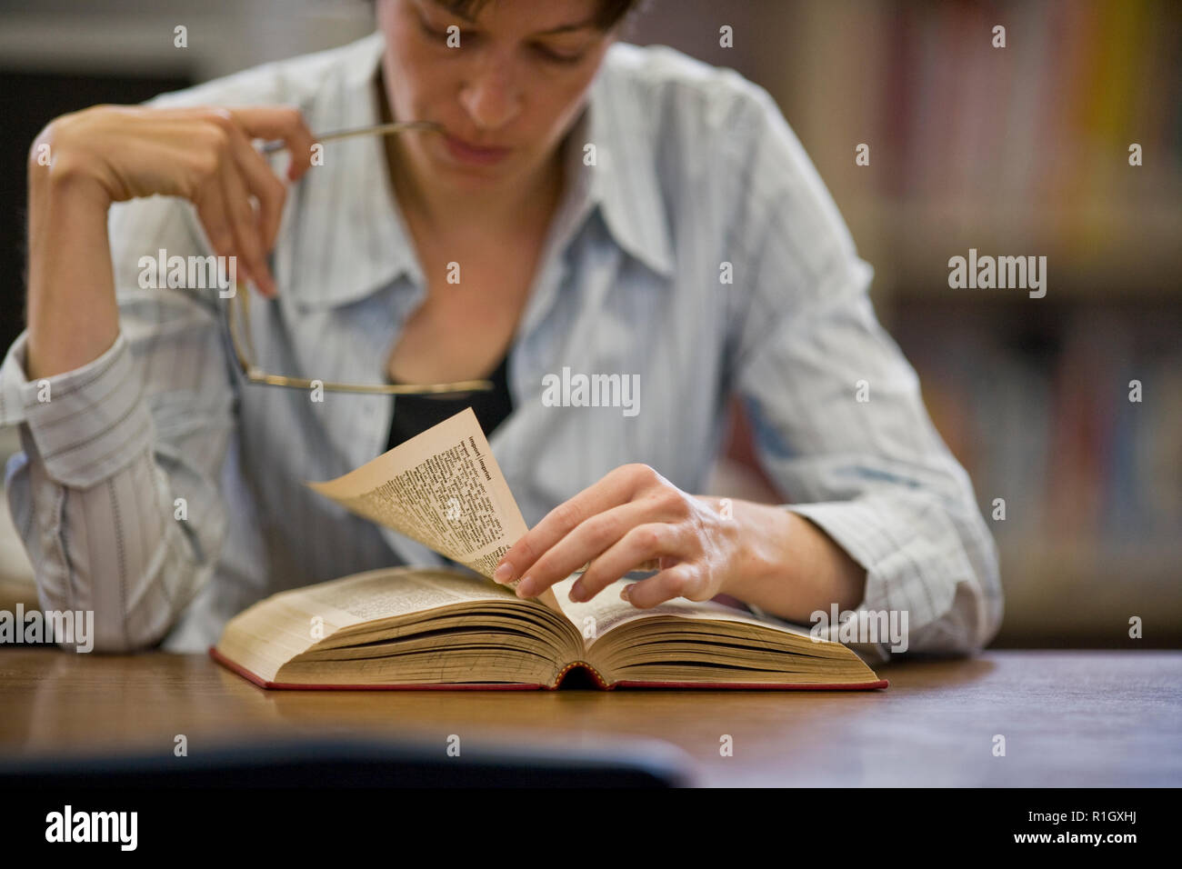 Focalizzato metà donna adulta la lettura di un libro in una libreria. Foto Stock