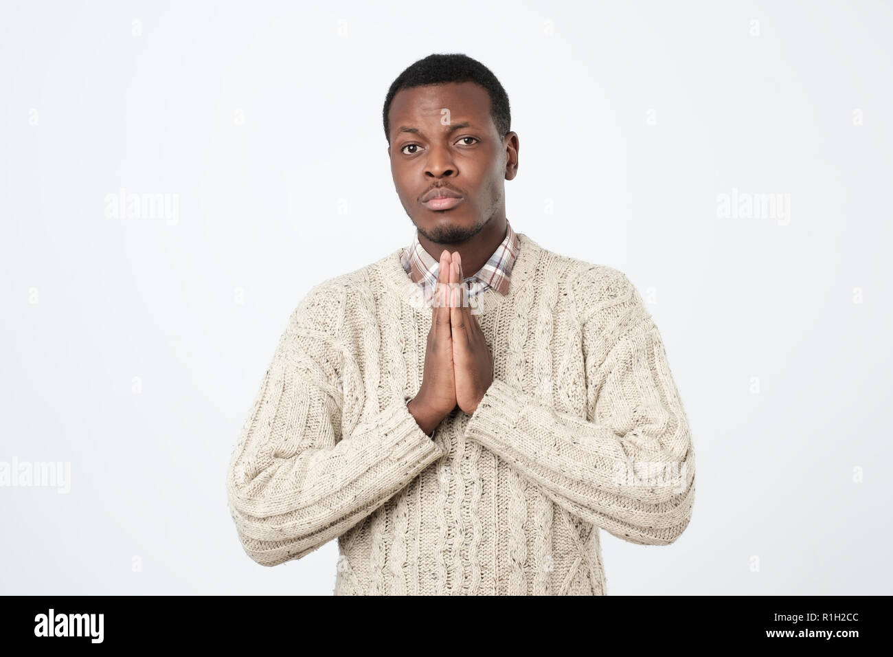 Pregando African American uomo sperare per il meglio. Chiedendo a Dio per la buona fortuna e successo, perdono. Foto Stock