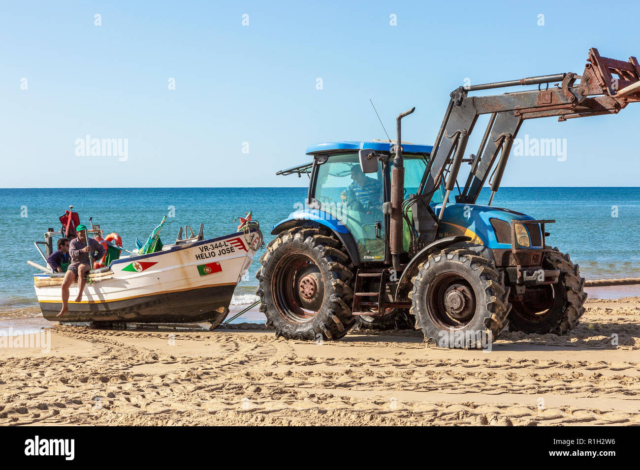 I pescatori locali aventi la loro barca da pesca cazzate fino sulla spiaggia, Monte Gordo, Algarve, PORTOGALLO Foto Stock