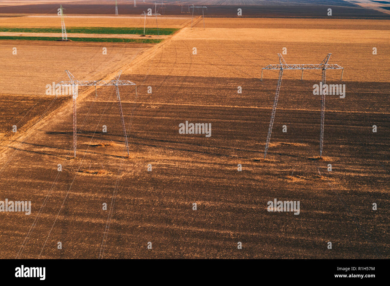 Di energia elettrica ad alta tensione tralicci per la trasmissione di potenza nel campo da fuco pov Foto Stock