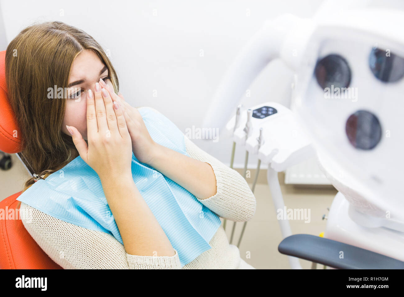 Dental Clinic. Reception, l'esame del paziente. La cura dei denti. Ragazza giovane si sente dolore dal dentista. Foto Stock