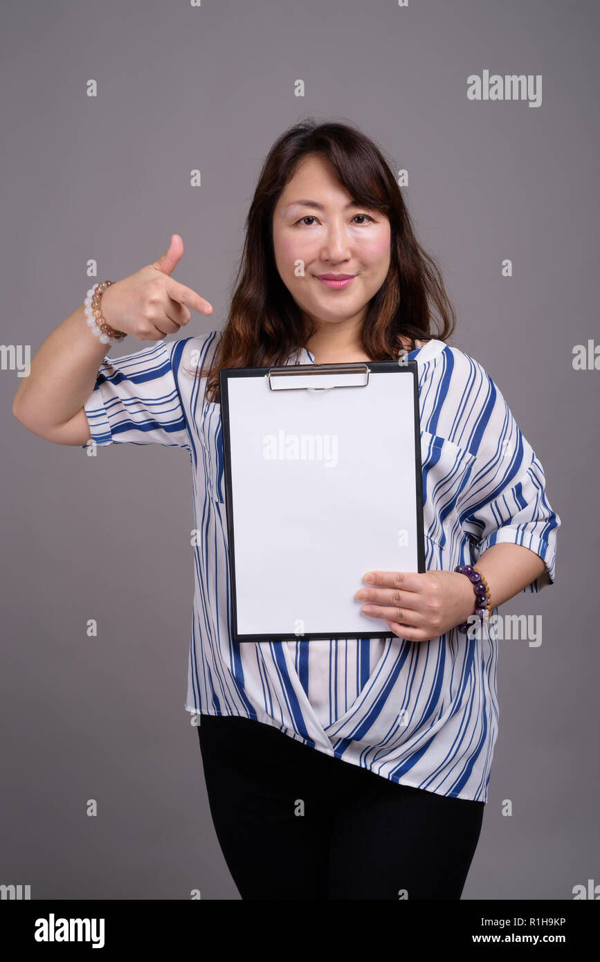 Imprenditrice giapponese negli appunti di contenimento con il bianco della carta vuoto Foto Stock