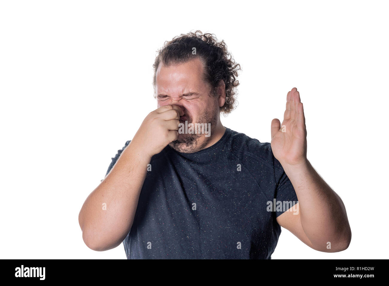 Un giovane uomo detiene o pizzichi il suo naso chiuso a causa di un puzzolente odore di Foto Stock
