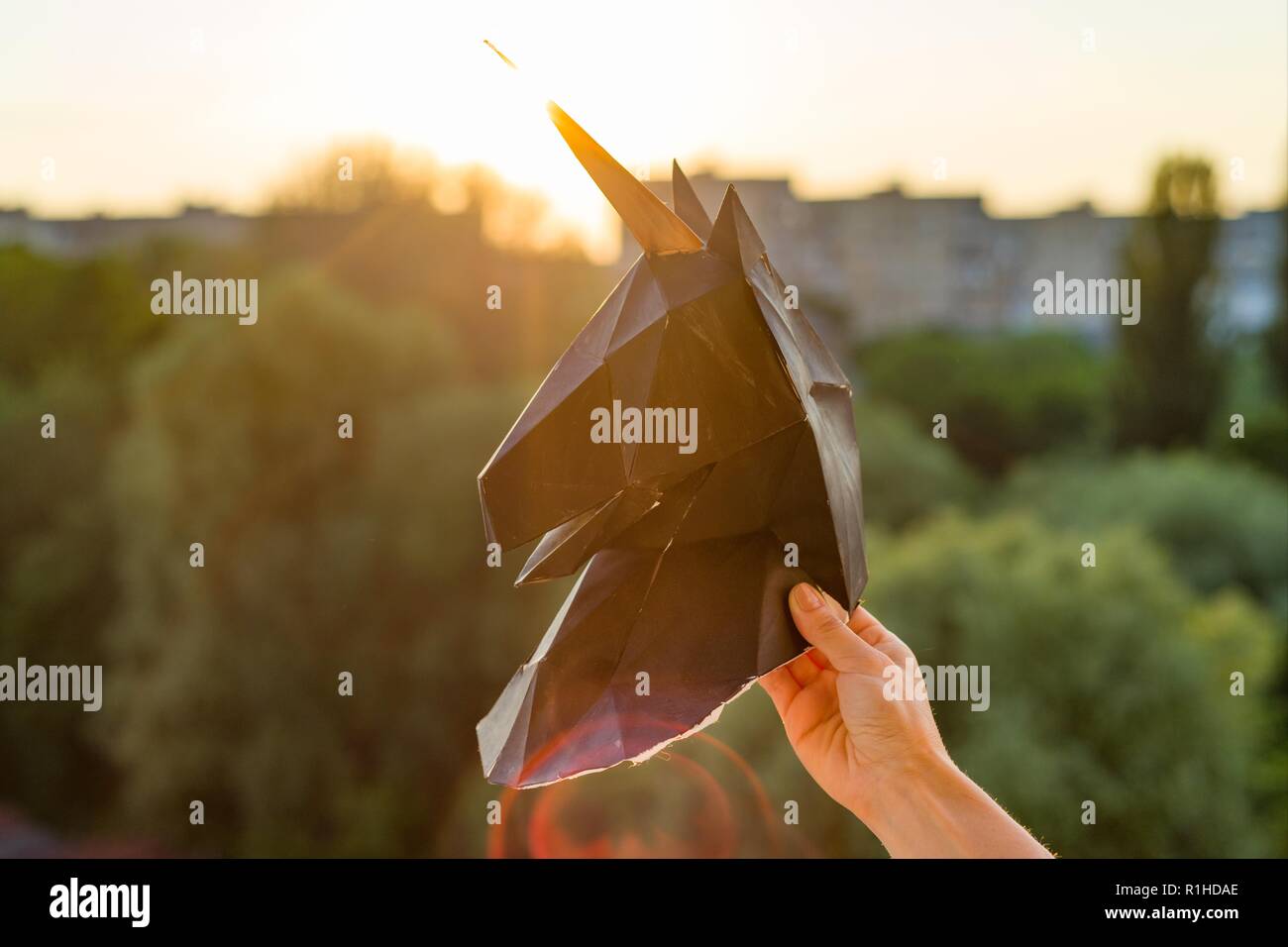 Silhouette della testa di carta nera 3d unicorn su sfondo al tramonto. Foto Stock