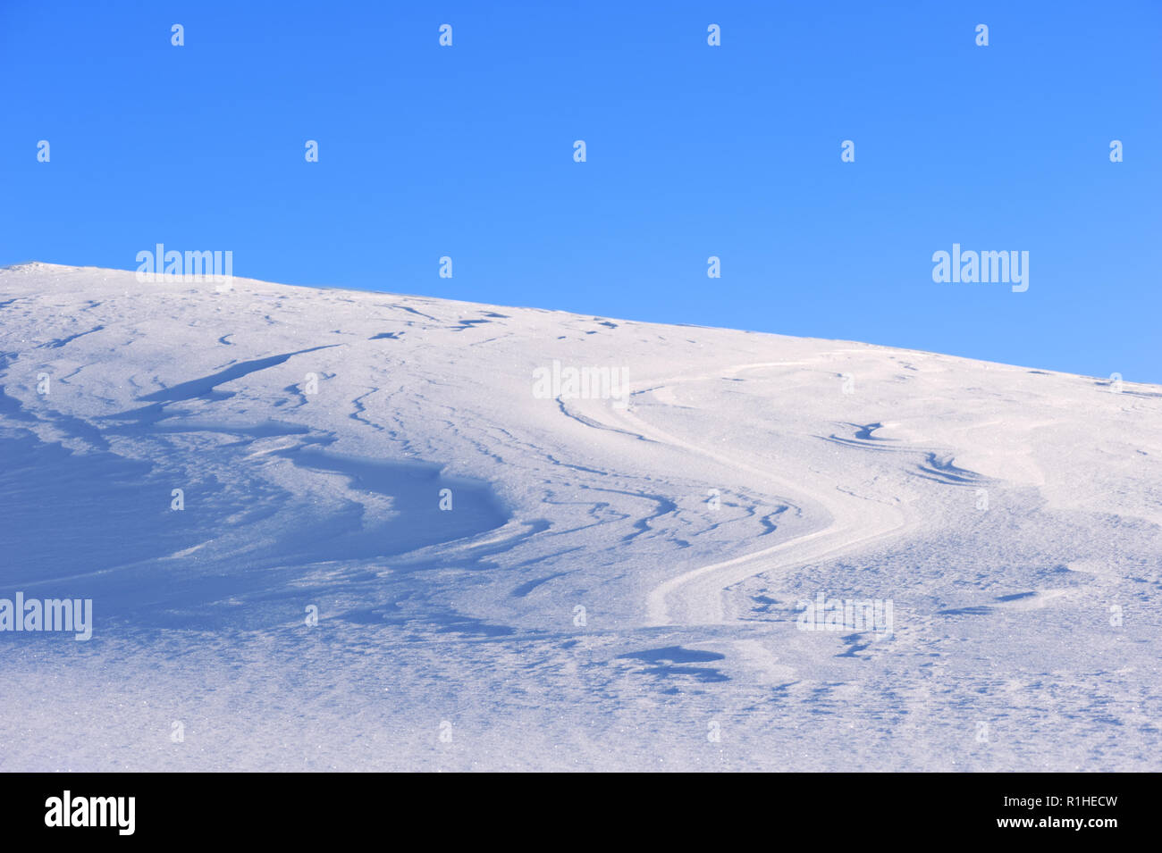 Snowy hill contro il cielo blu e chiaro. Foto Stock
