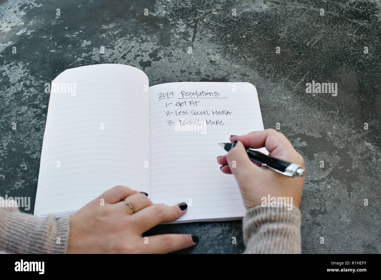 La donna le mani la scrittura di nuovi anni di risoluzioni per il 2019 in un ufficiale Foto Stock