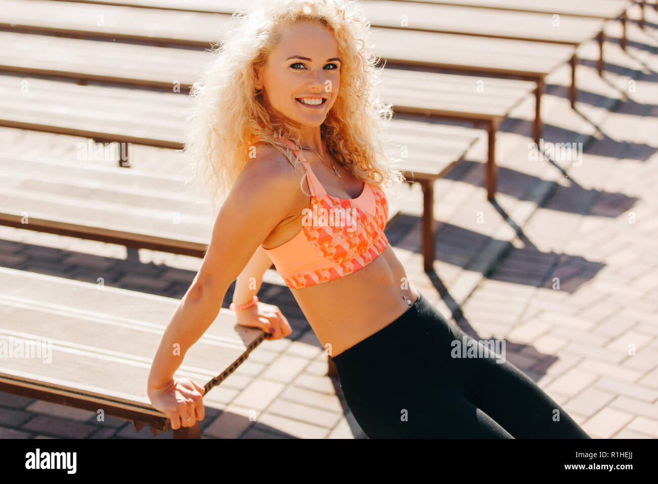 Immagine della donna sportive esercitano tra panche in giornata estiva nel parco. La colorazione al di sotto del film Foto Stock