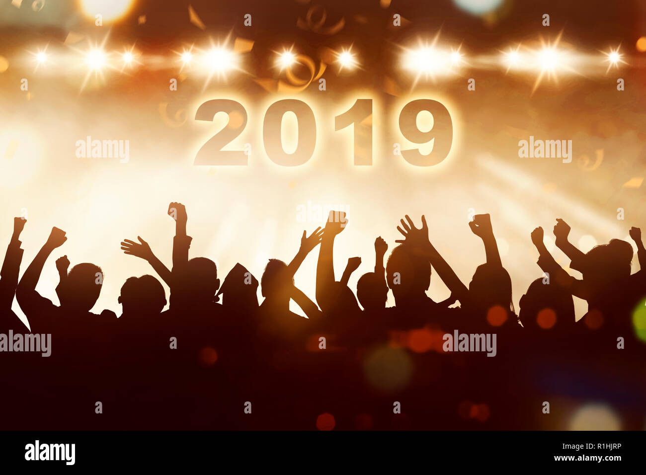 Silhouette di persone celebrano il nuovo anno con 2019 e battenti coriandoli. Felice Anno Nuovo 2019 Foto Stock