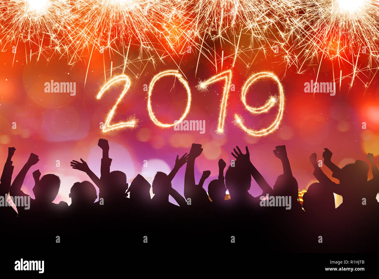 Silhouette di persone celebrano il nuovo anno con 2019 dalle scintillanti fuochi d'artificio del cielo. Felice Anno Nuovo 2019 Foto Stock