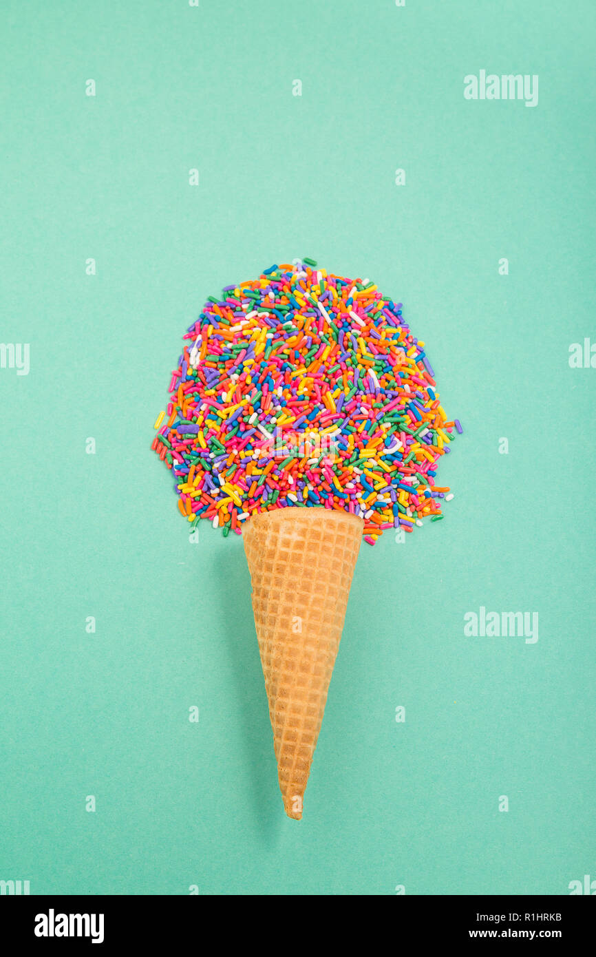 Cono gelato con un pizzico nella forma di un convogliatore su un pallido sfondo verde Foto Stock