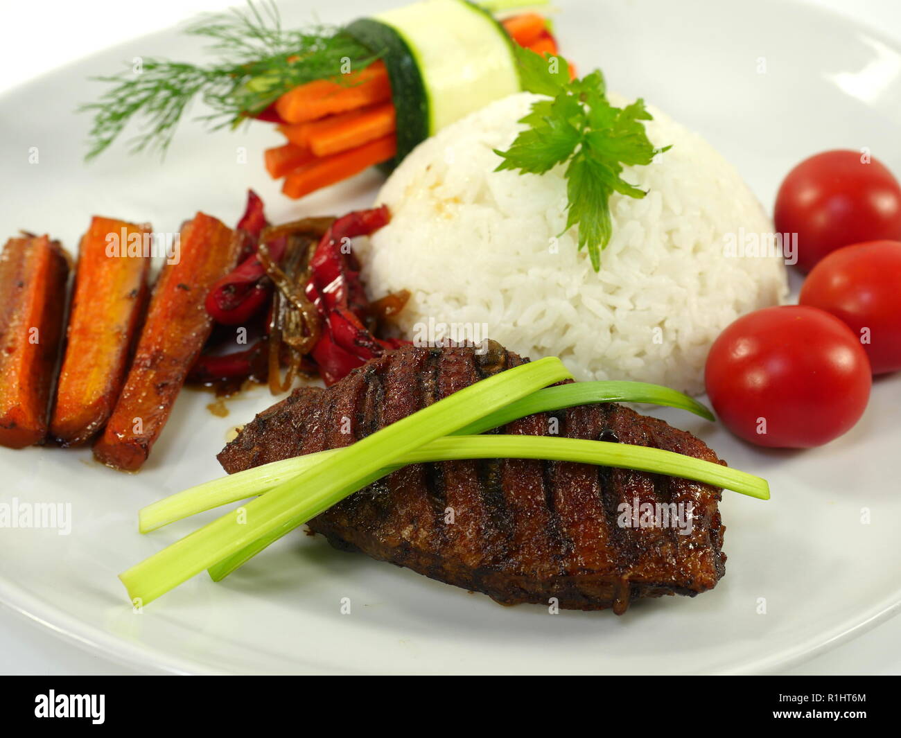 Filetto arrosto di anatra con riso su piastra bianca Foto Stock