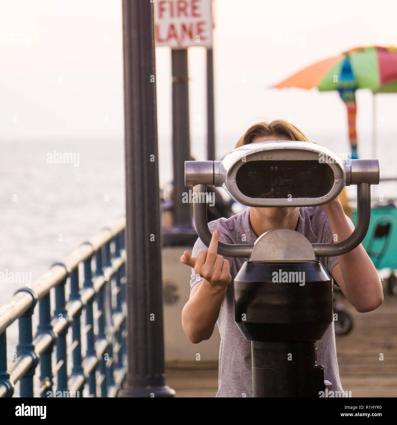 Un ragazzino impertinente con telescopio al Molo di Santa Monica Foto Stock