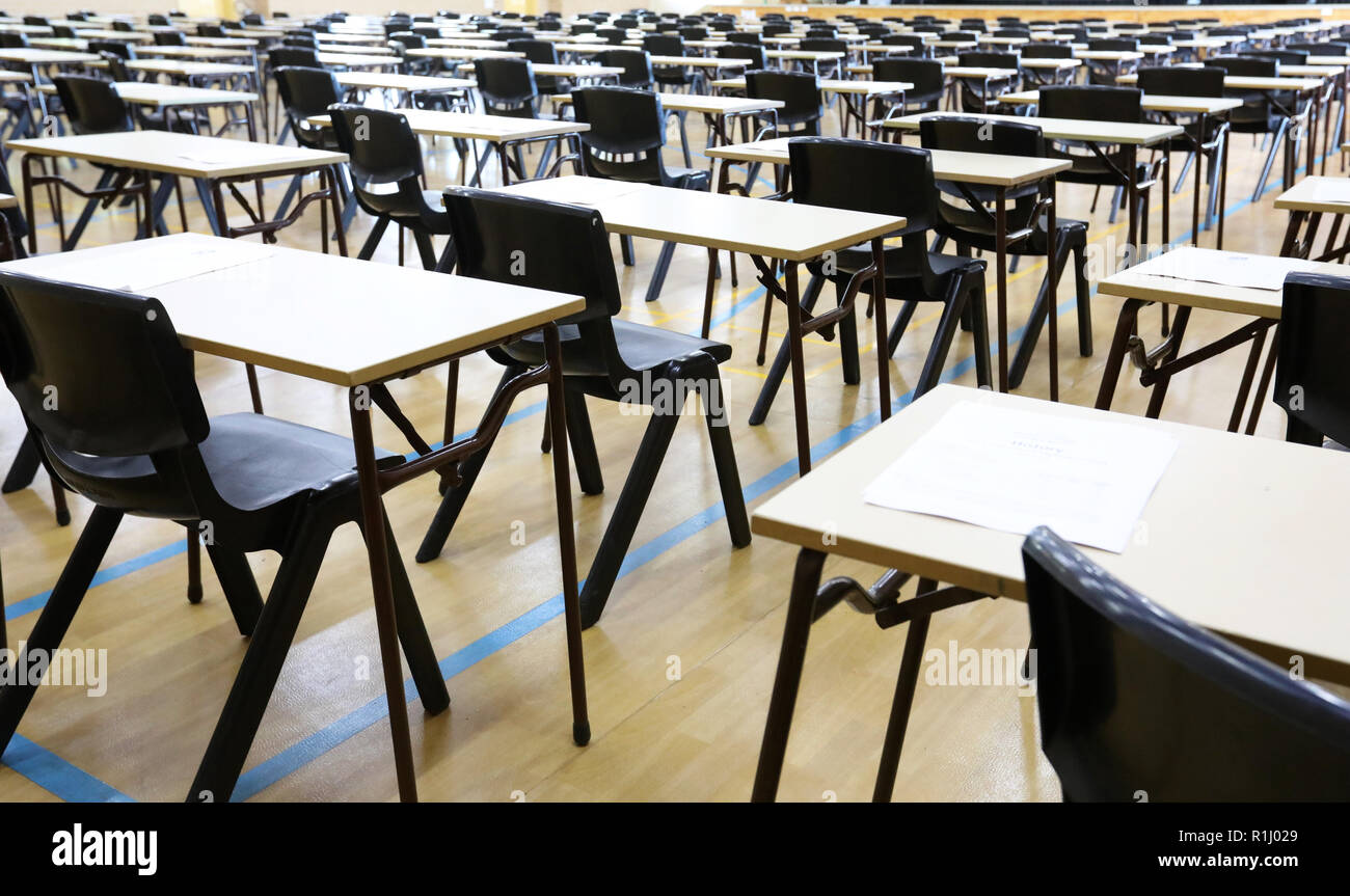 Vista di una grande sala esame sala esame e scrivanie tavoli allineati in file pronto per gli studenti di una scuola superiore di venire e sedersi i loro esami carta per prove Foto Stock