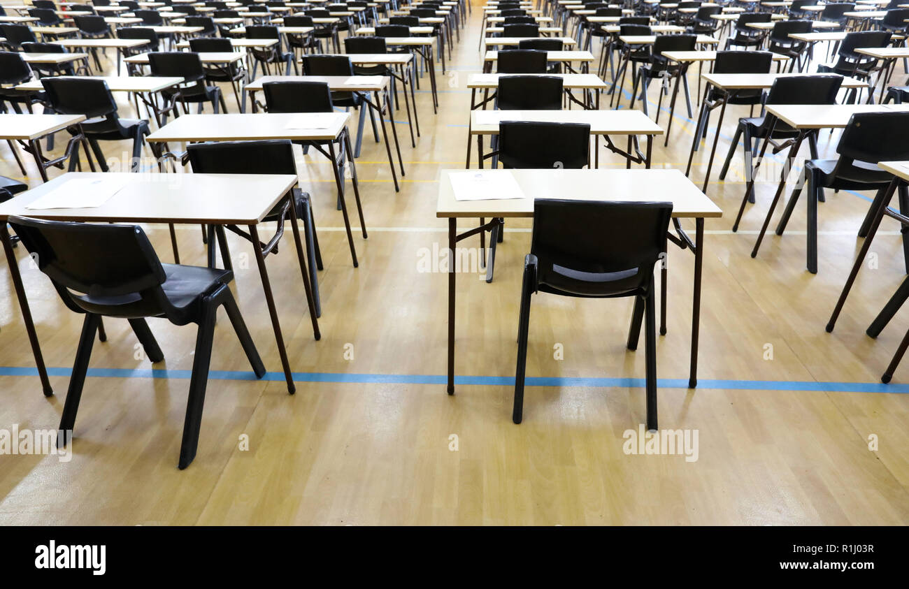 Vista di una grande sala esame sala esame e scrivanie tavoli allineati in file pronto per gli studenti di una scuola superiore di venire e sedersi i loro esami carta per prove Foto Stock