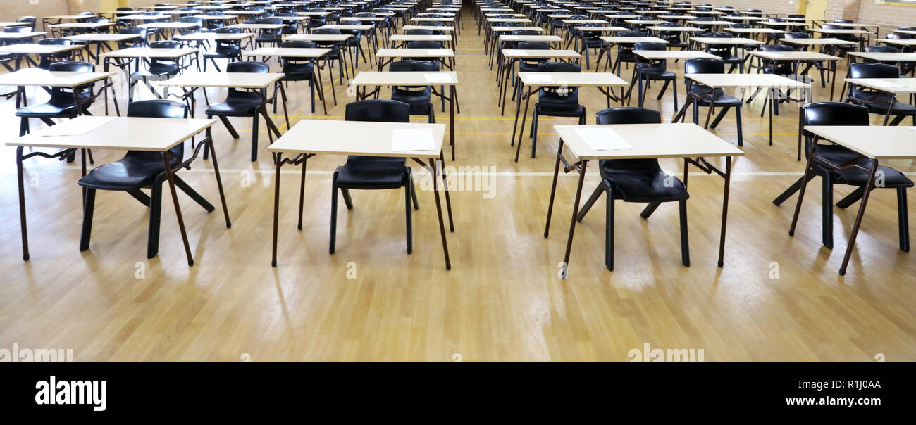 Vista di una grande sala esame sala esame e scrivanie tavoli allineati in file pronto per gli studenti di una scuola superiore di venire e sedersi i loro esami carta per prove Foto Stock