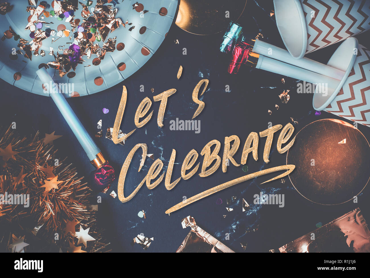 Vogliamo festeggiare mano pennello font sulla tavola di marmo con party cup,parte soffiante,tinsel,coriandoli.divertente festeggiare holiday party time table top view.blu Foto Stock