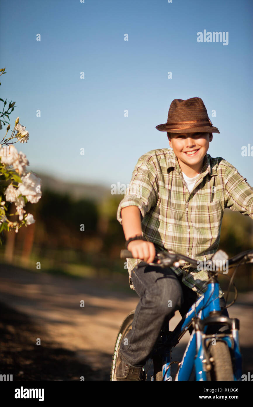 Ritratto di ragazzo sorridente sulla sua bicicletta. Foto Stock