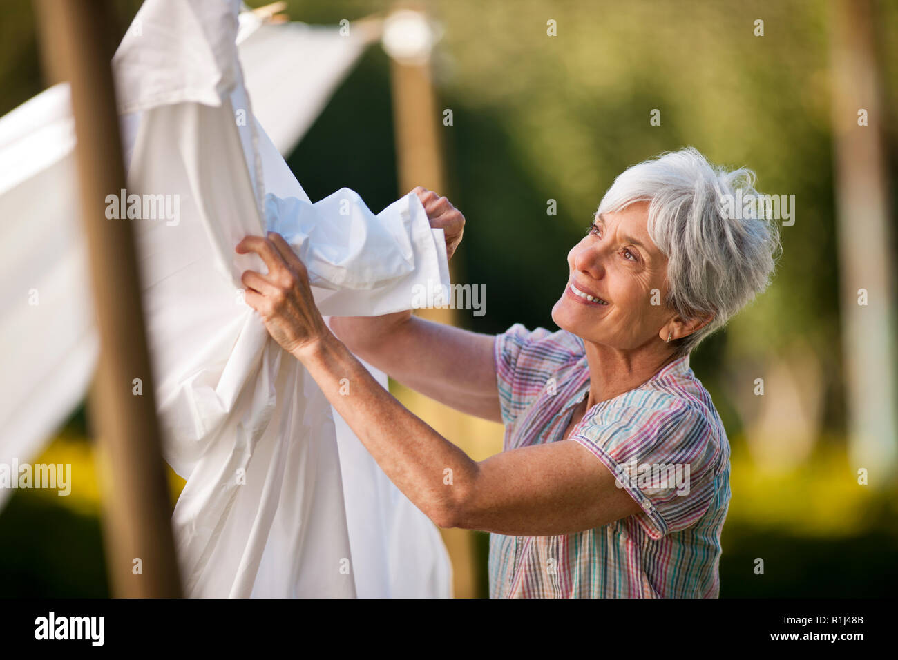 Ragazzo giovane scherzosamente il rotolamento nell'erba. Foto Stock