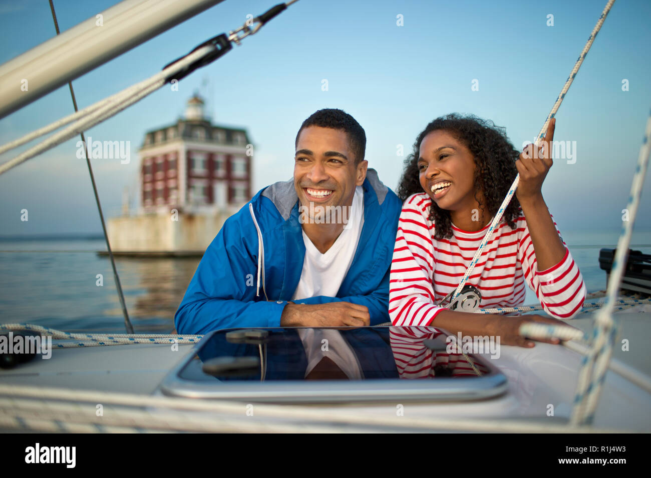 Sorridente coppia giovane appendere fuori su una barca. Foto Stock