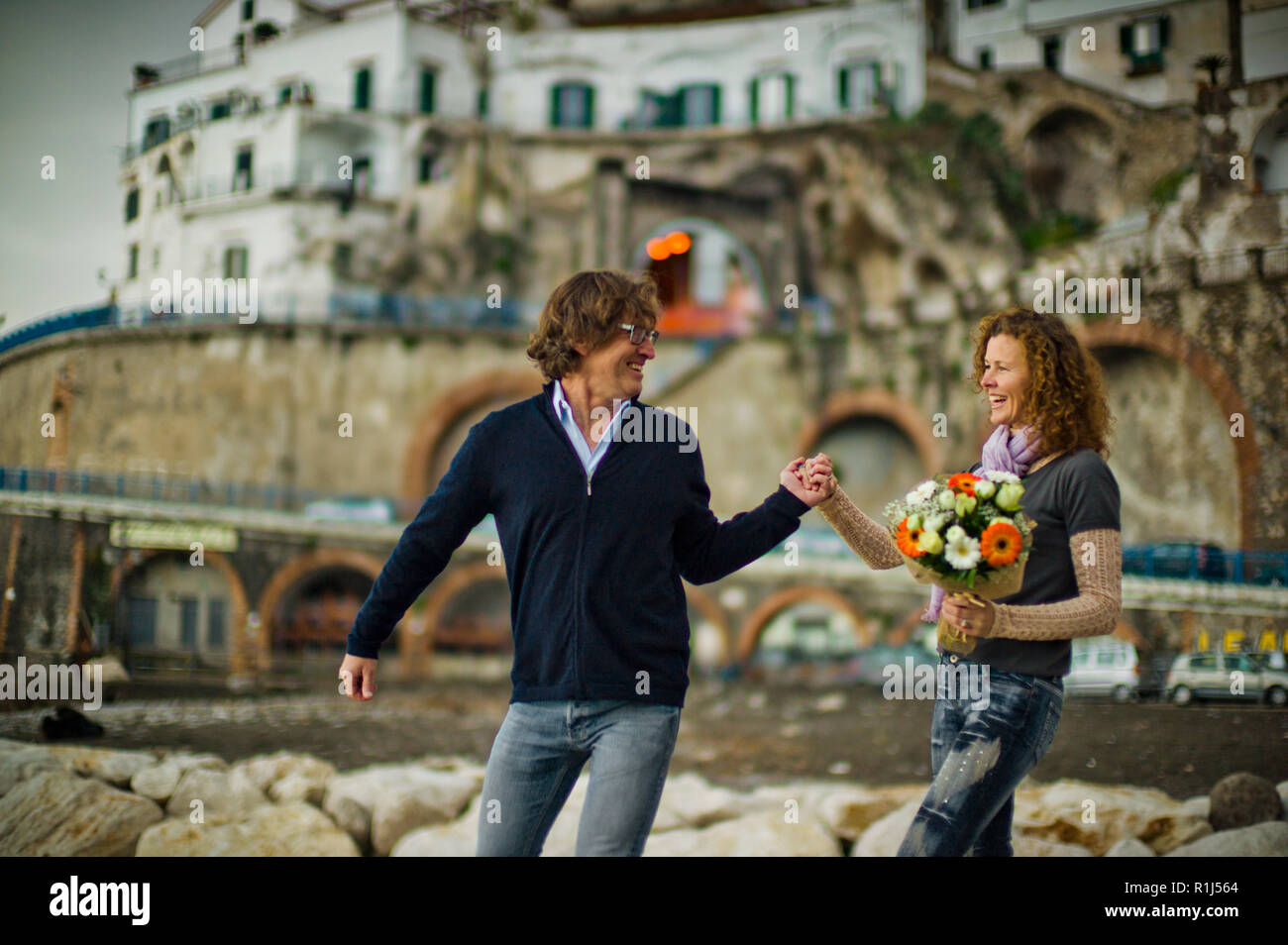 Felice Coppia di mezza età felicemente passeggiando lungo la costa. Foto Stock