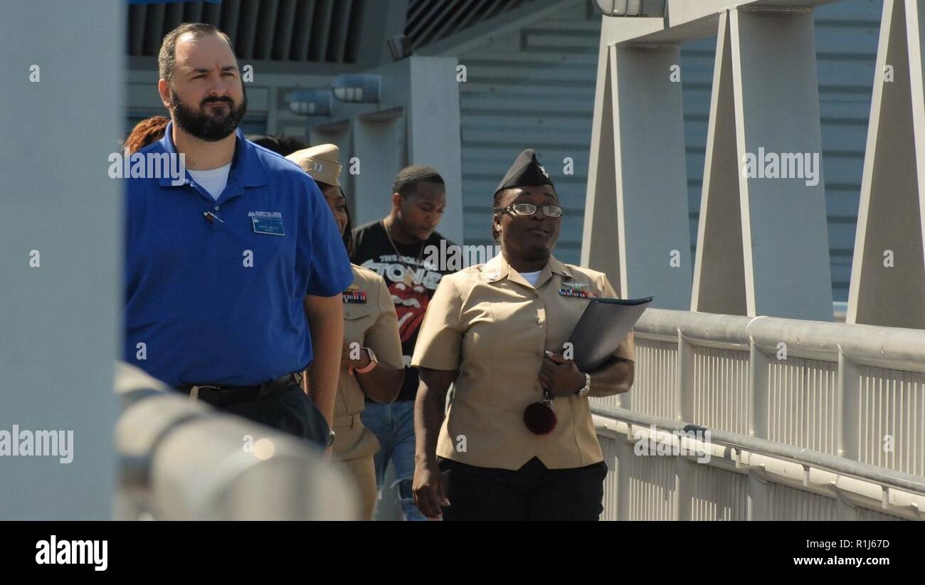 Educatore museale Giuseppe Miechle, dall'Hampton Roads Museo Navale, conduce la ri-l'arruolamento di parti attraverso la passerella. Il Hampton Roads Museo Navale ha ospitato un re-arruolamento cerimonia a bordo della USS Wisconsin (BB-64) questo pomeriggio. AZ2(AW) Jasmine James, dalla flotta Readiness Center Mid-Atlantic, orgogliosamente tenuto la sua mano destra e ri-arruolato oggi di fronte ai membri della sua famiglia e del suo comando. Il re-l'arruolamento è stato uno speciale; il re-l'arruolamento di funzionario è stato tenente Valeta Wilson James, dal a galla Training Center Mayport; il re-enlistees' sorella-in-legge. Il Wisconsin è un ritiro Foto Stock