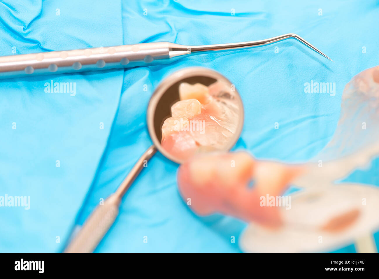 La riflessione di denti finti in uno specchio dentale Foto Stock