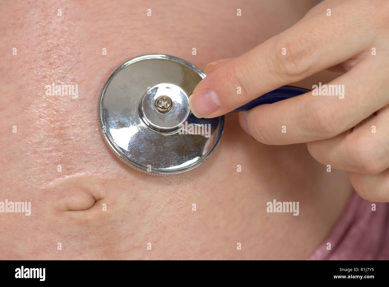 Ventre della donna incinta e la mano con uno stetoscopio Foto Stock