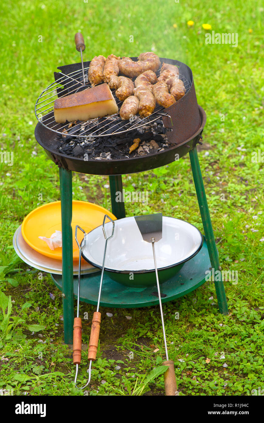 Barbecue portatile con salsicce e lardo terminato Foto Stock