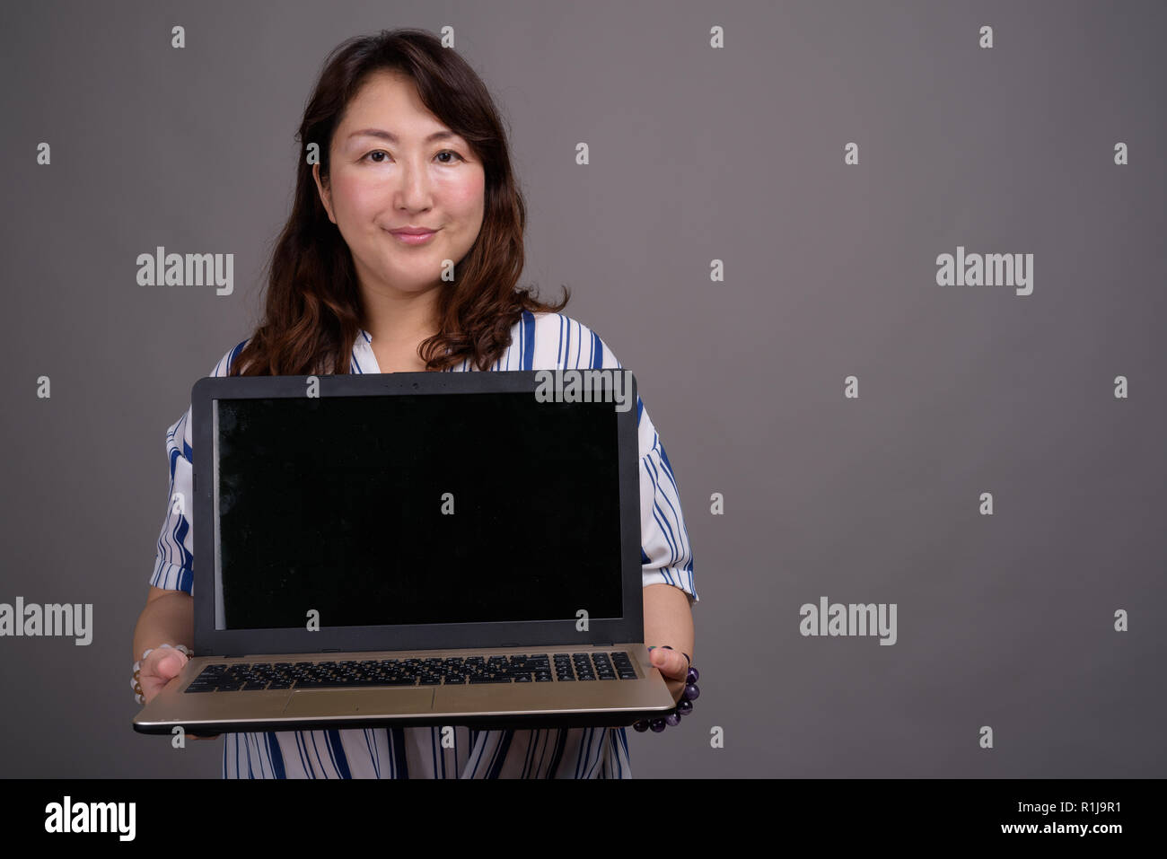 Asian imprenditrice che mostra lo spazio di copia dal computer portatile Foto Stock