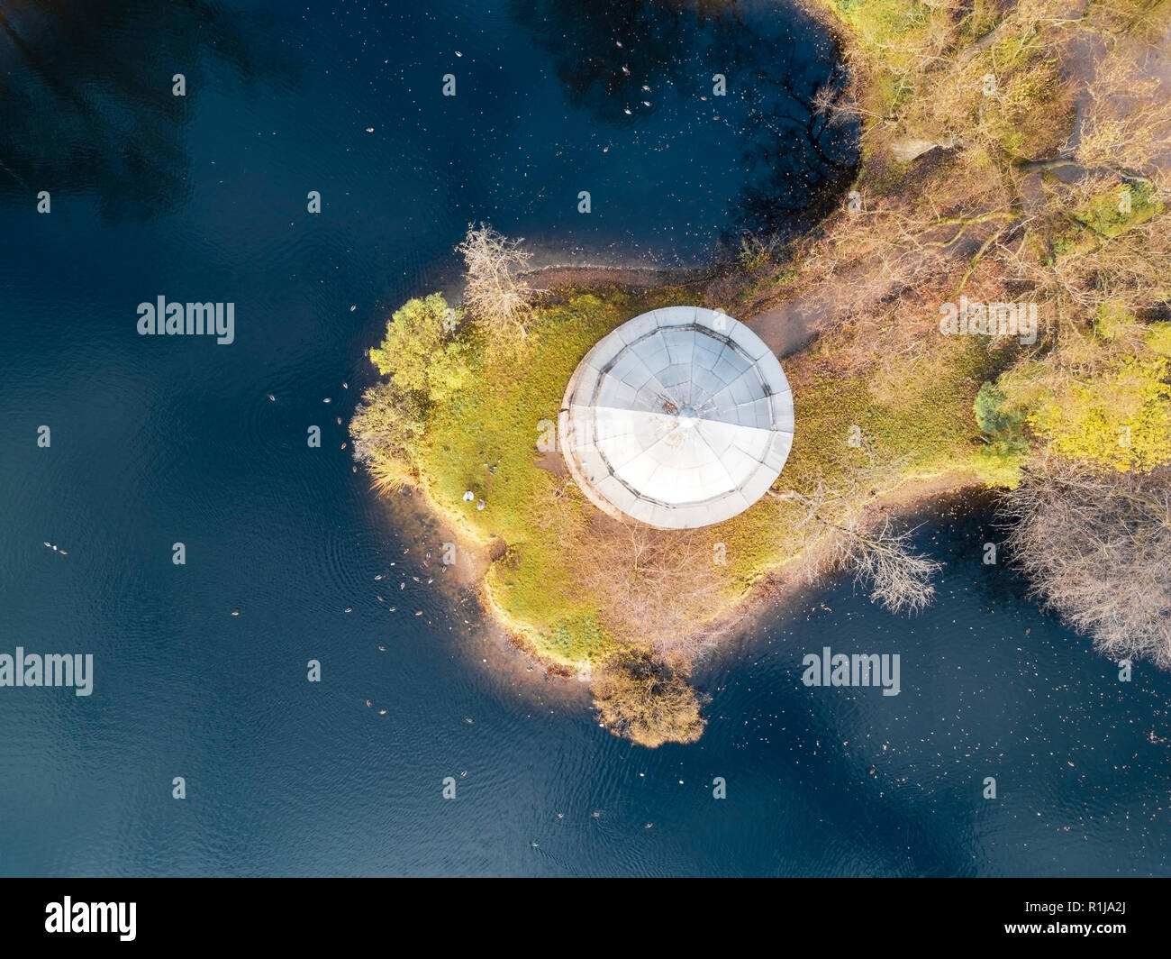Antenna; drone vista della mattina autunnale nel bellissimo parco della città; il resto e area ricreativa con acque blu del lago; grazioso gazebo in pietra tetto sulla riva del m Foto Stock