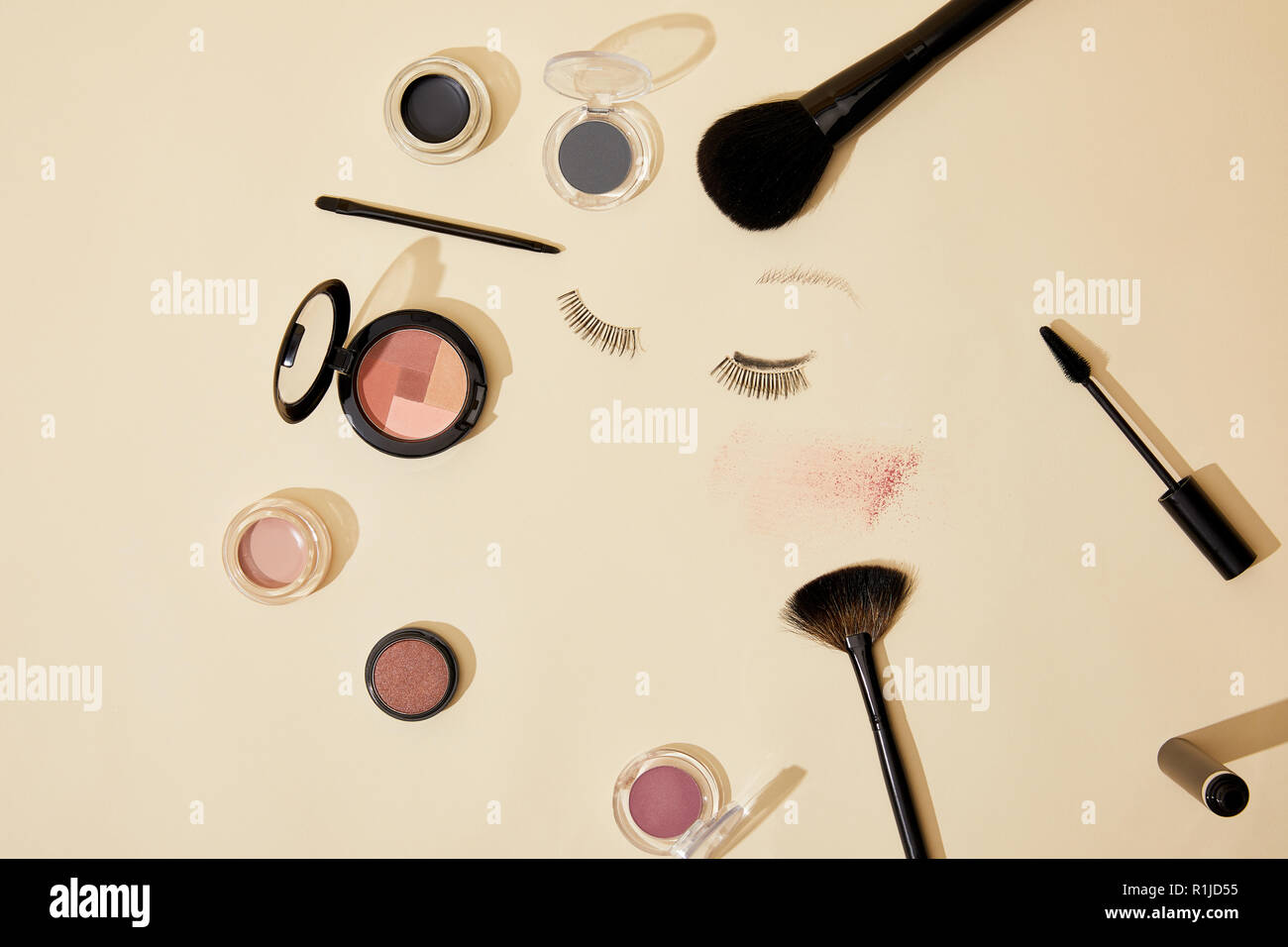 Vista dall'alto di vari cosmetici giacente sulla superficie di colore beige Foto Stock