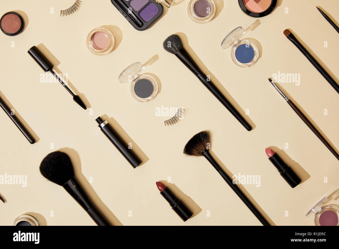 Vista superiore della composizione di diversi prodotti cosmetici giacente sulla superficie di colore beige Foto Stock