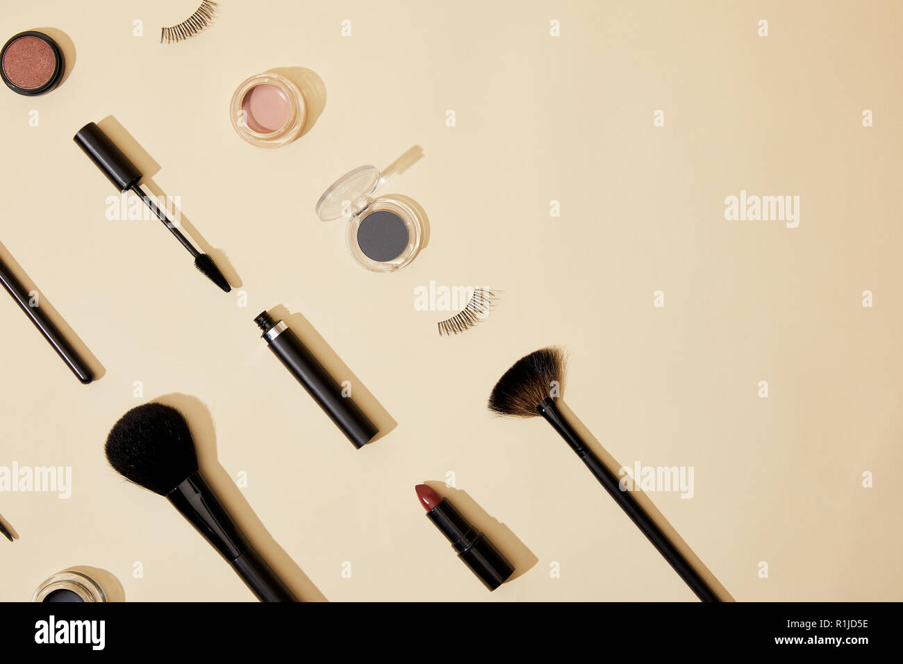 Laici piatta con la composizione di diversi prodotti cosmetici giacente sul piano portapaziente beige Foto Stock