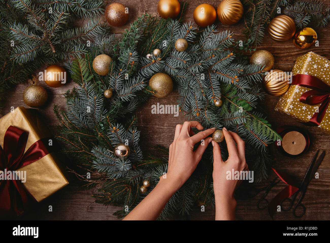 Immagine ritagliata della donna fare decorazione di Natale a tavola in legno Foto Stock