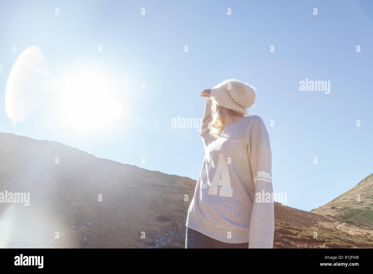 Vista dal basso della donna che guarda la montagna sotto la luce del sole, dei Carpazi, Ucraina Foto Stock