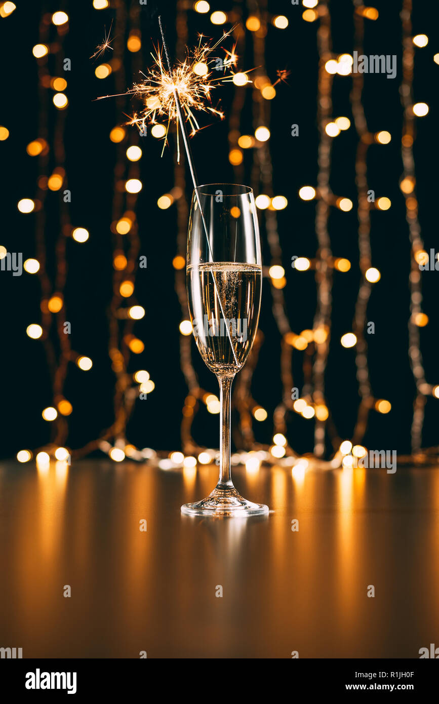 Champagne con natale sparkle su garland sfondo luminoso Foto Stock