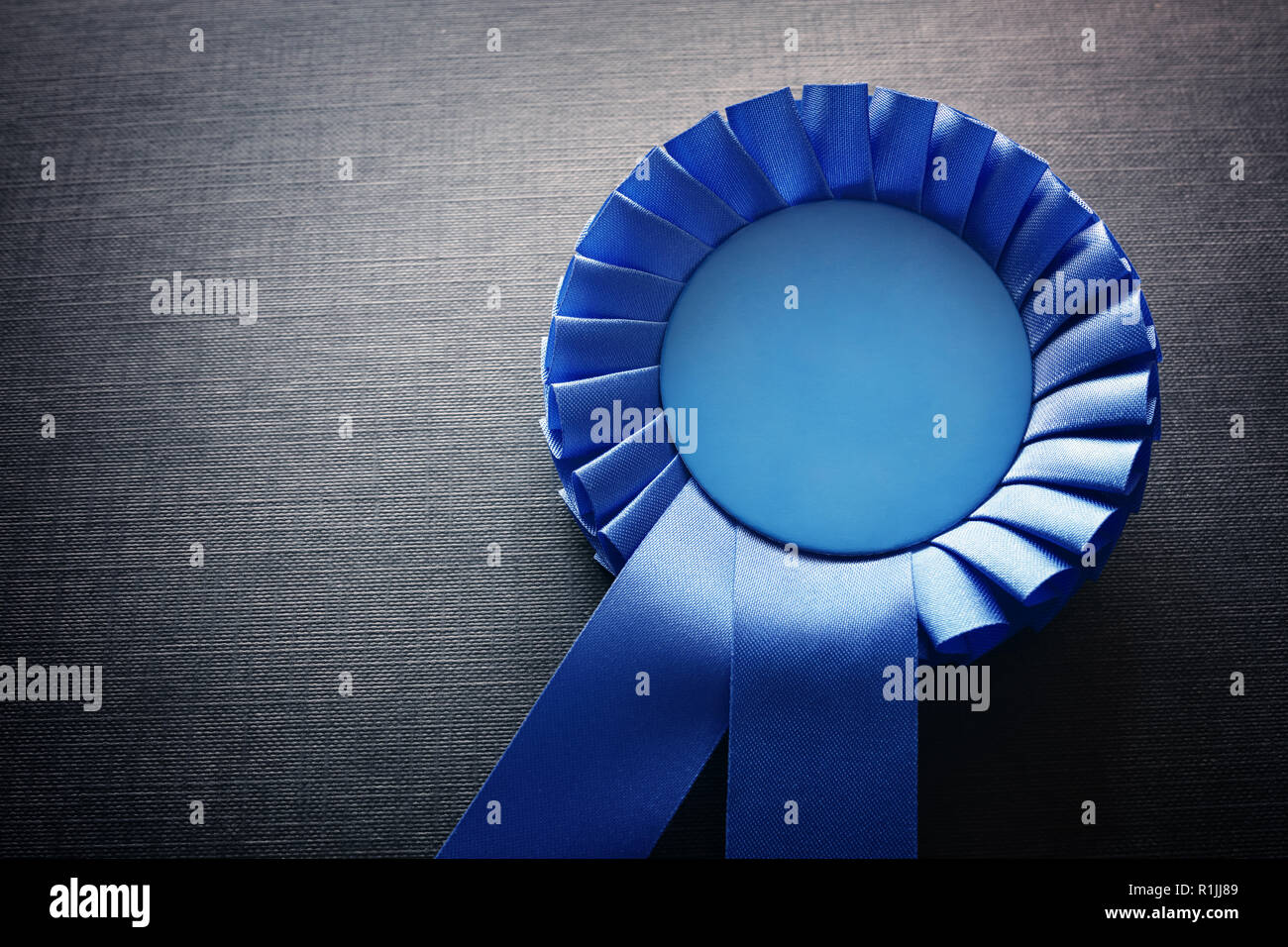 Premio blu rosette con nastri e copia spazio su sfondo nero Foto Stock