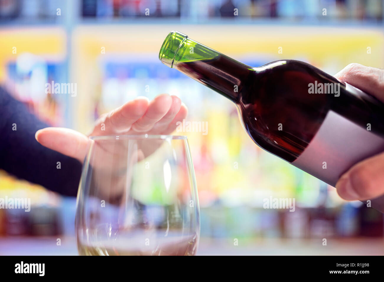 Womans respingendo la mano più alcol dalla bottiglia di vino in bar Foto Stock